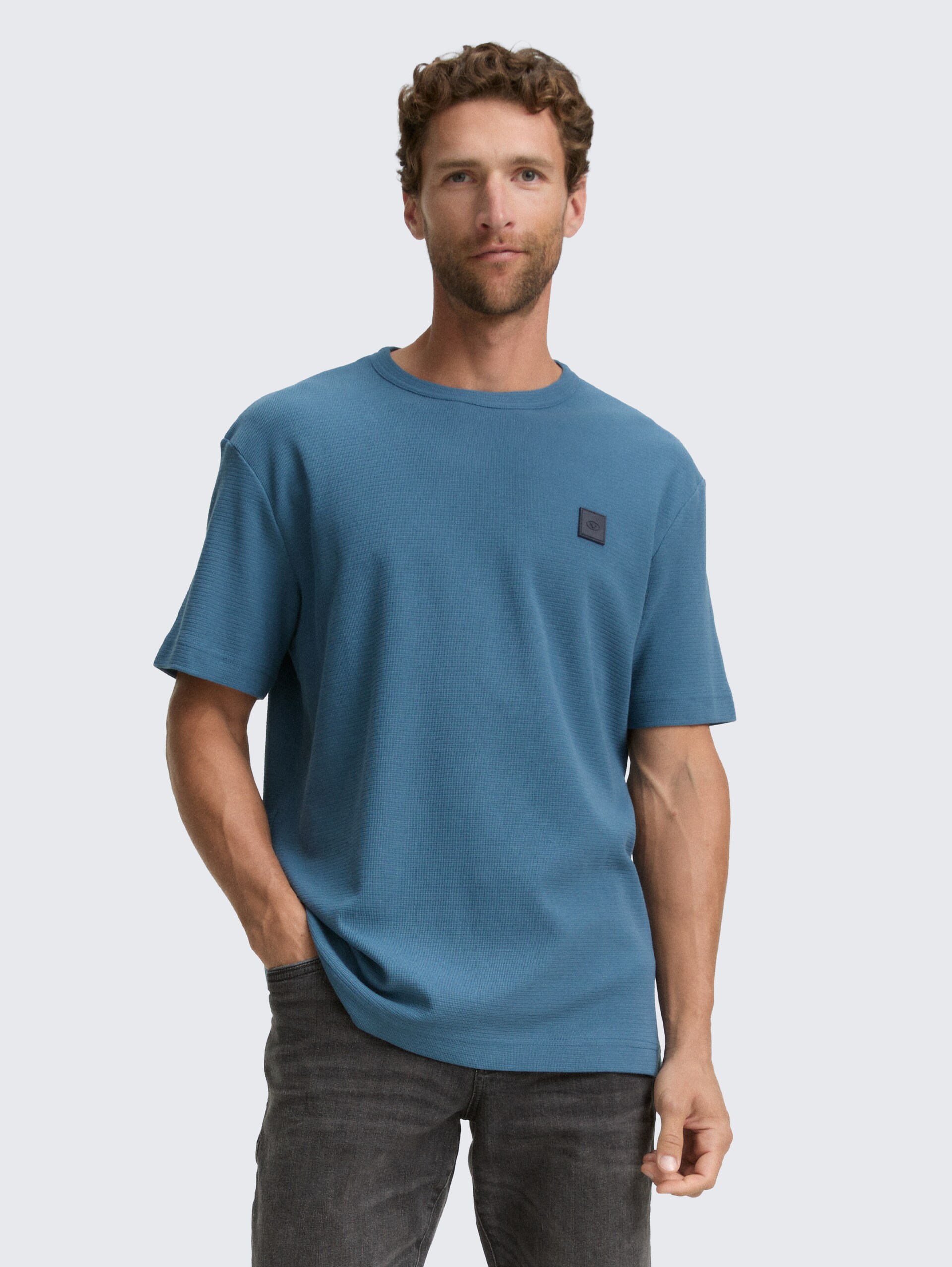 T-Shirt mit Logo-Badge - real teal blue - Ausschnitt Model-Vorderansicht
