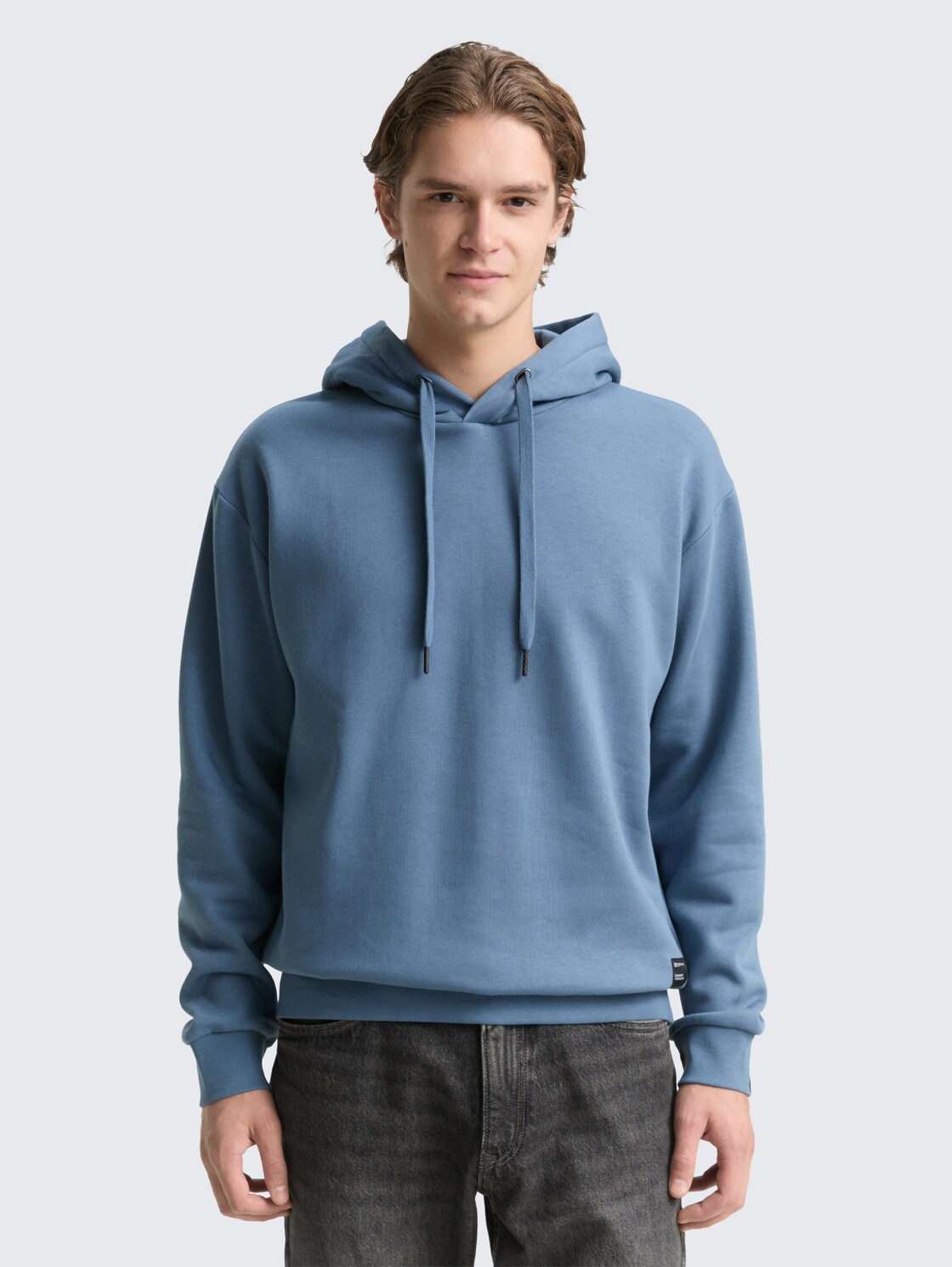 Hoodie sweatshirt with logo badge - dusty denim blue - Neckline model front view