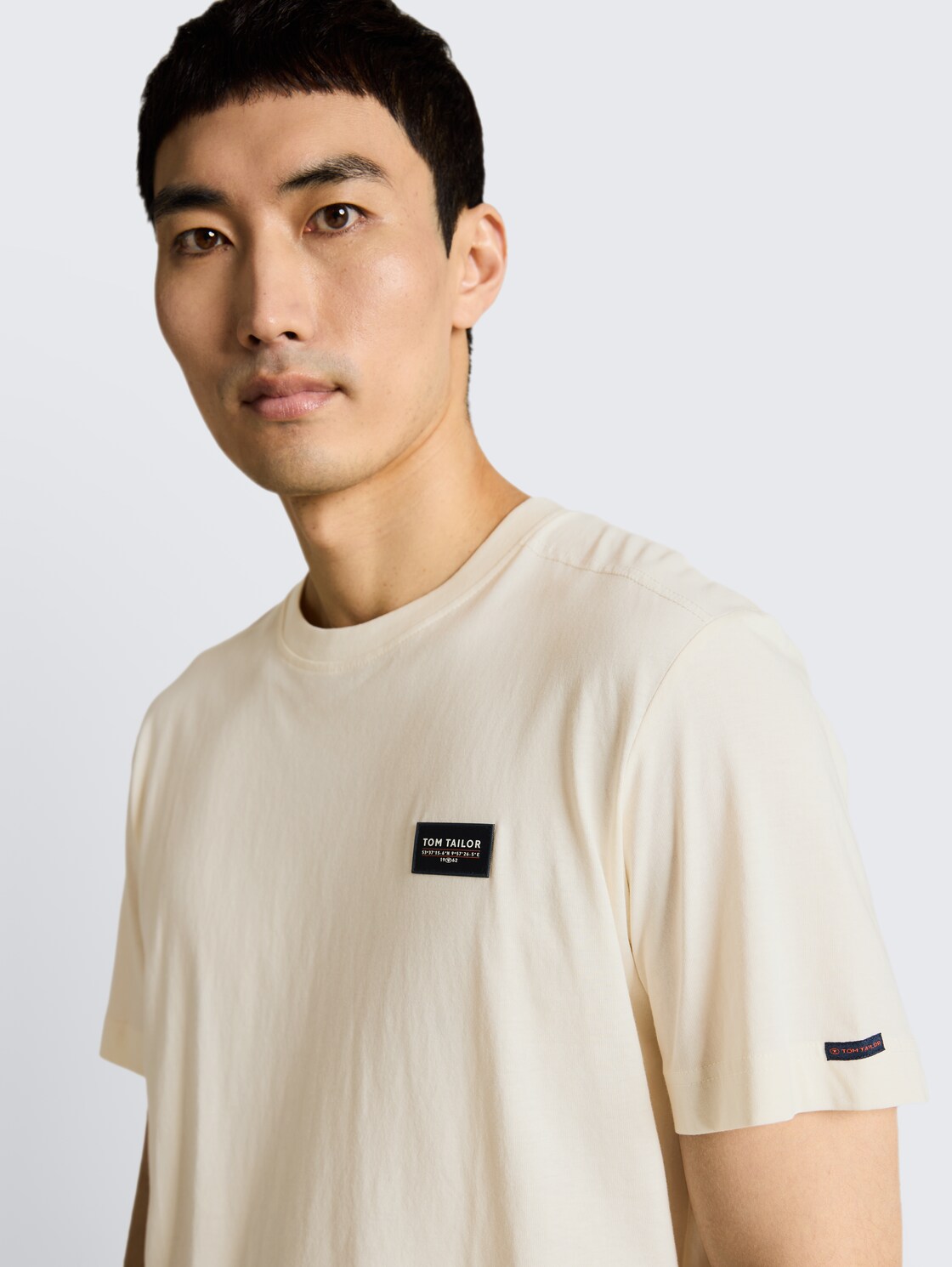 T-Shirt aus Baumwolle mit Logo-Badge - Gardenia White - Detail-Model-Ansicht