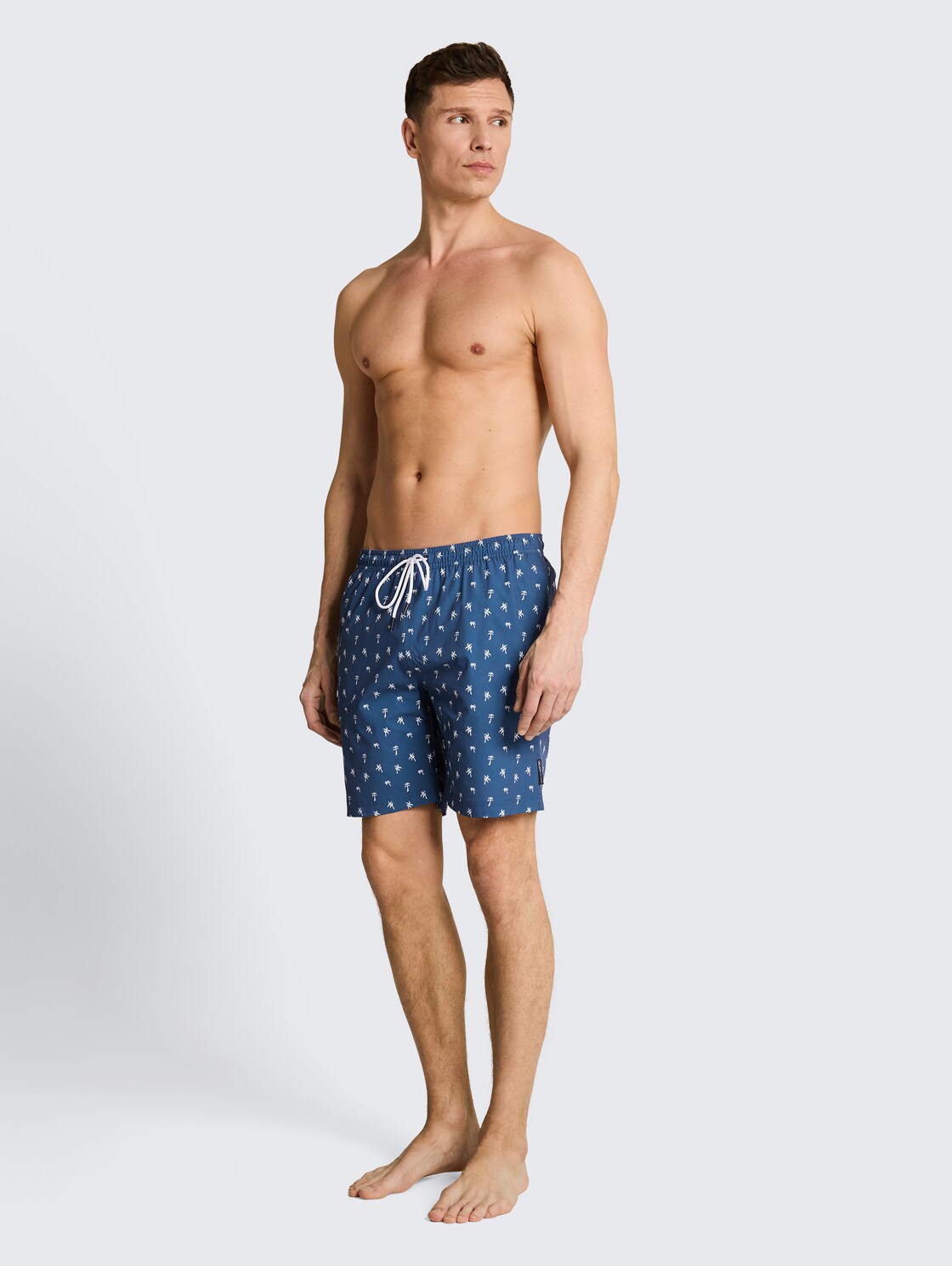 Patterned swim shorts - blue white mini palm print - Model front view