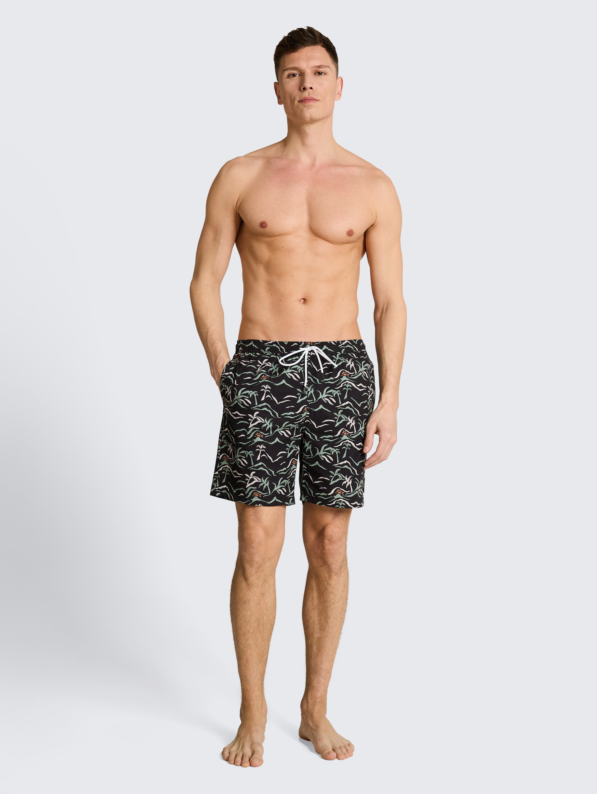 Badeshorts mit Muster - black green tropical print - Model-Vorderansicht