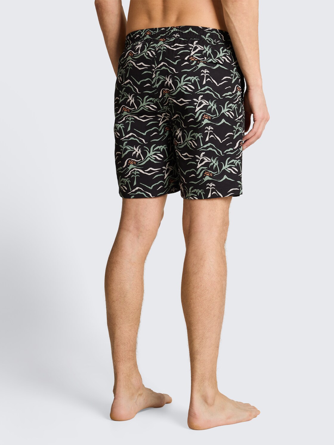 Badeshorts mit Muster - black green tropical print - Auschnitt Model-Rückansicht