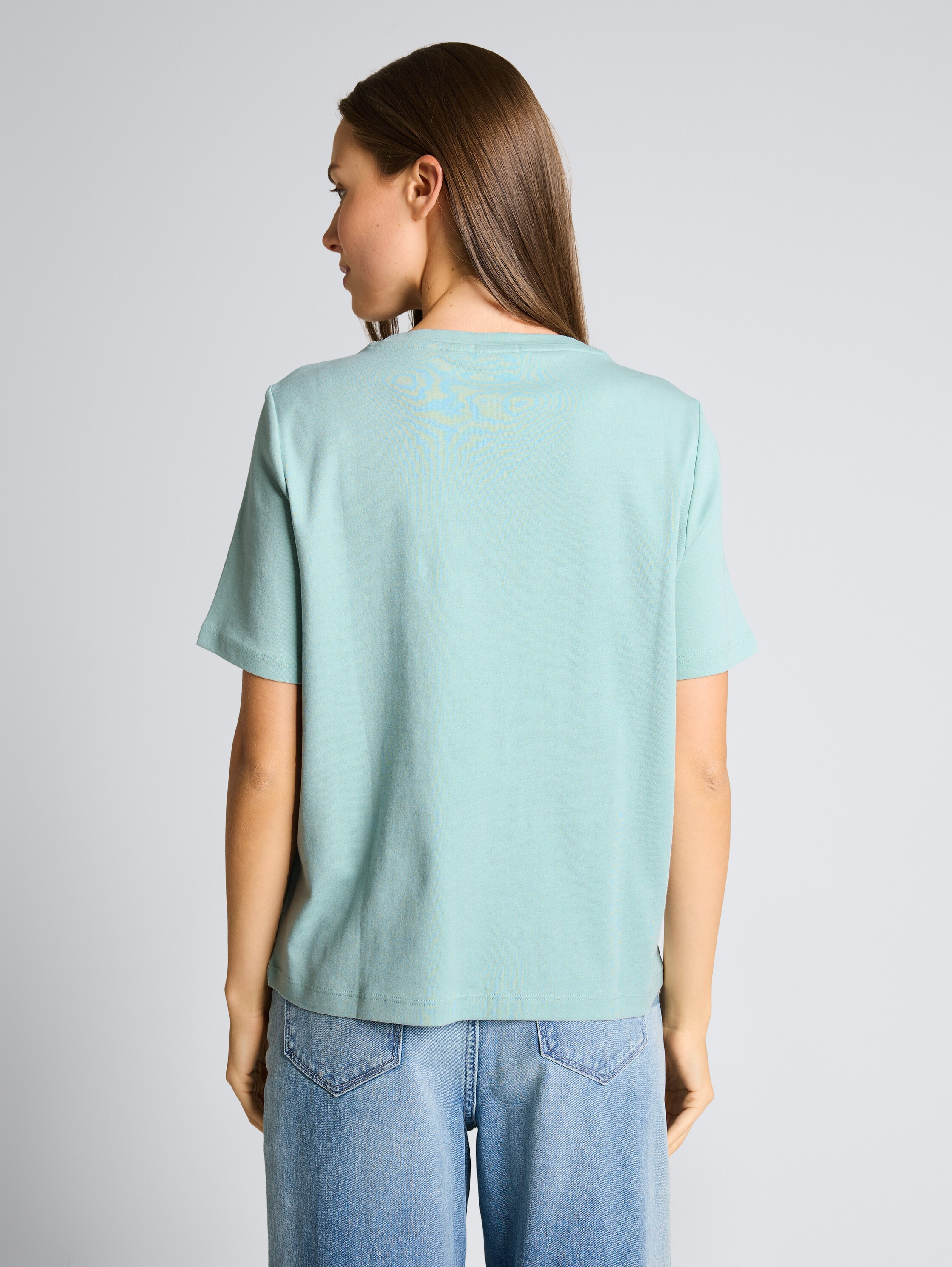 T-Shirt aus Baumwolle - light blue green - Auschnitt Model-Rückansicht